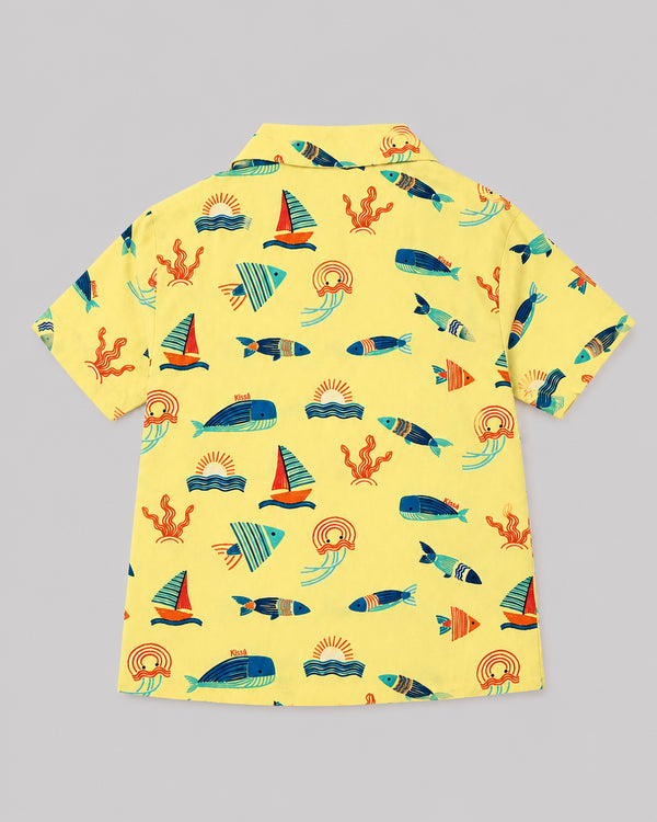 Back view of boys ocean themed shirt in yellow with sailboat and whale print, flat lay