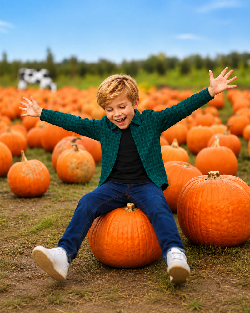 Boy celebrating in pumpkin patch wearing Green Printed Shirt, festive fall outfits for boys