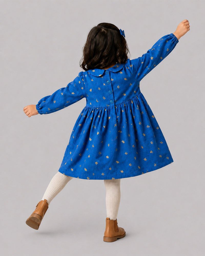 Girl in Gold Foil Blue Collar Dress twirling, back view, part of Kissa's girls clothing