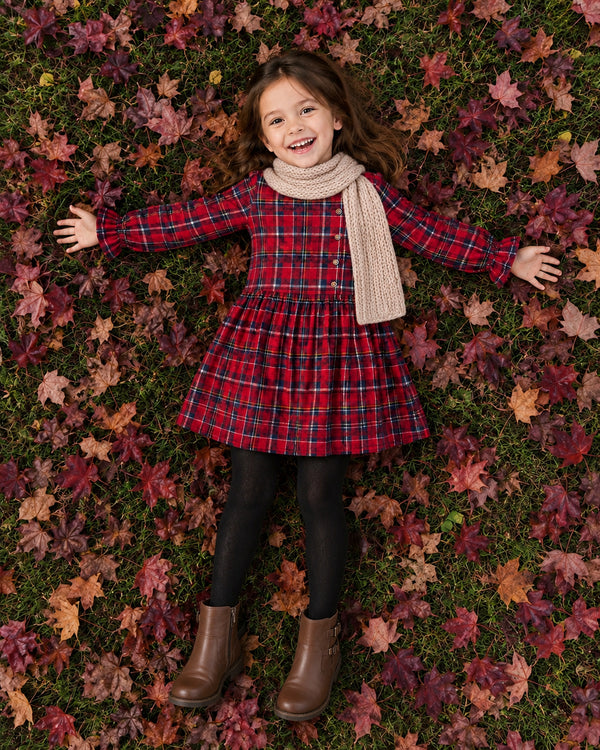 Girl lying in autumn leaves wearing Red Checks Frill Dress, cozy fall dresses for girls