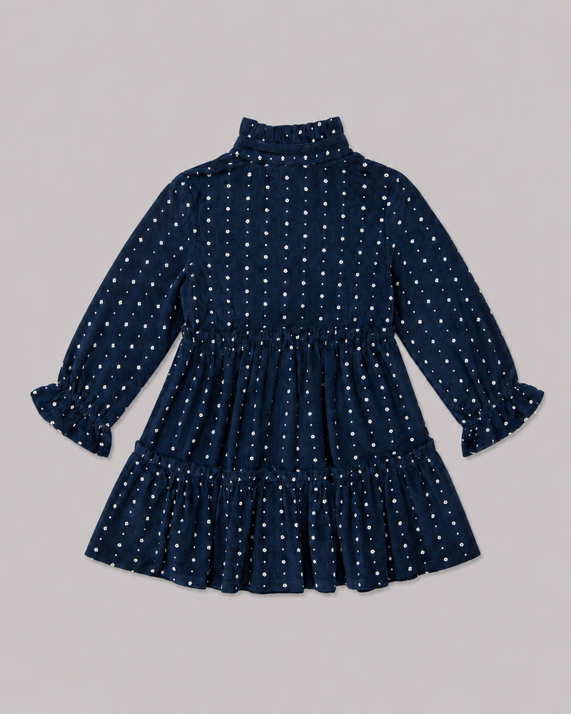 Back view of navy tiered dress with white floral dot print and ruffle collar, one of Kissa's dresses for girls