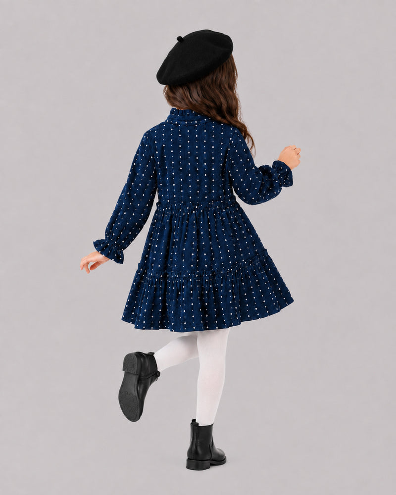 Girl twirling in navy polka dot dress and black beret, a charming pick for girls fall outfits