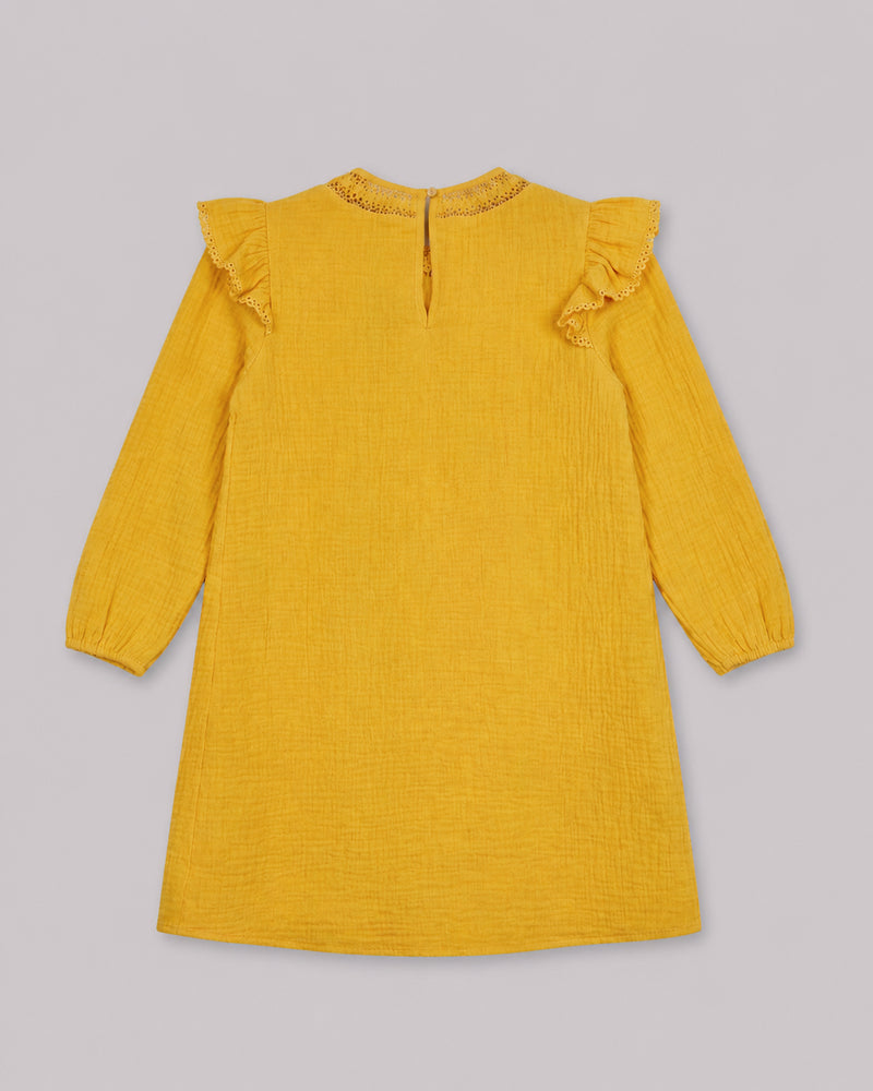 Back view of mustard yellow cotton dress with ruffle trim and keyhole closure, one of Kissa's dresses for girls