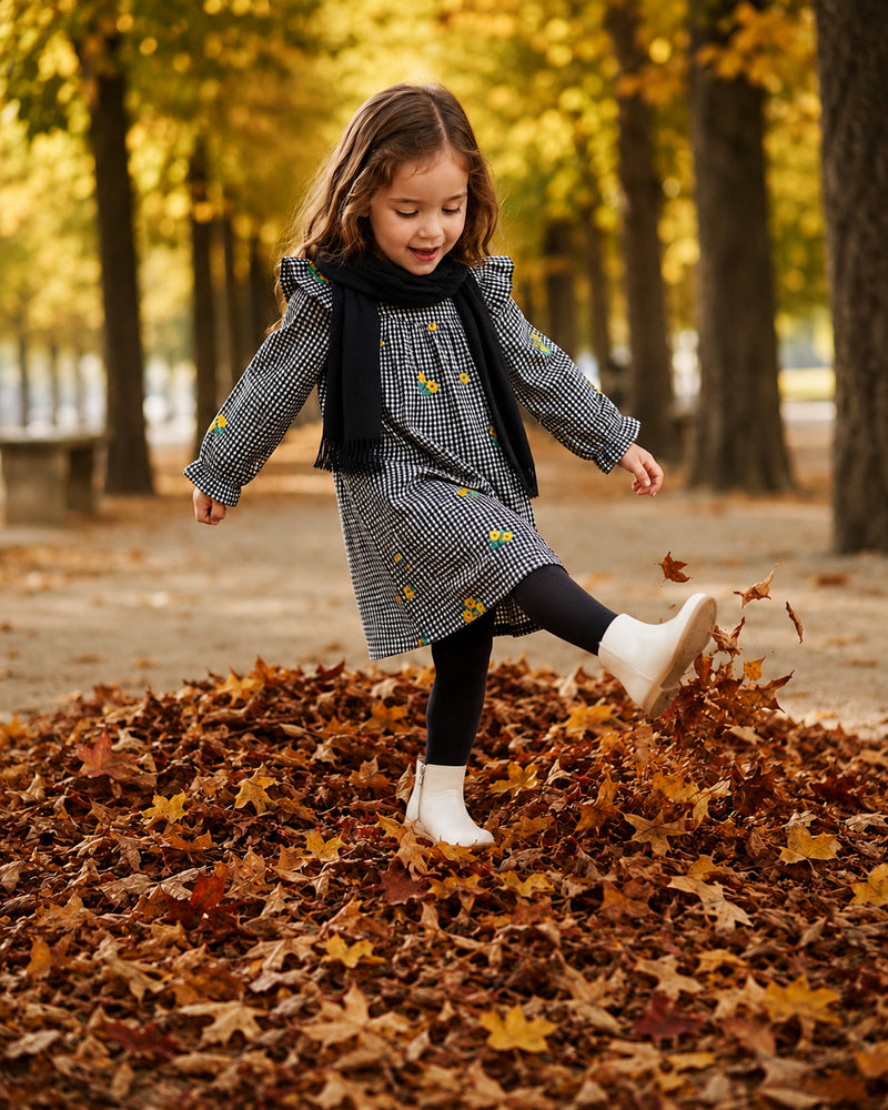 Girl kicking autumn leaves in gingham floral dress and scarf, a charming fall dresses for girls look
