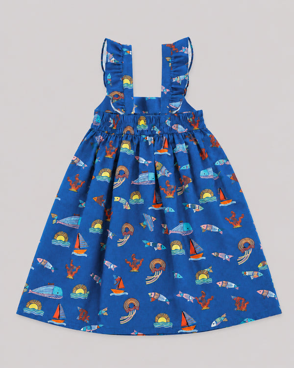 Back view of ocean themed dress for girls, blue with fish, whale, and sailboat print