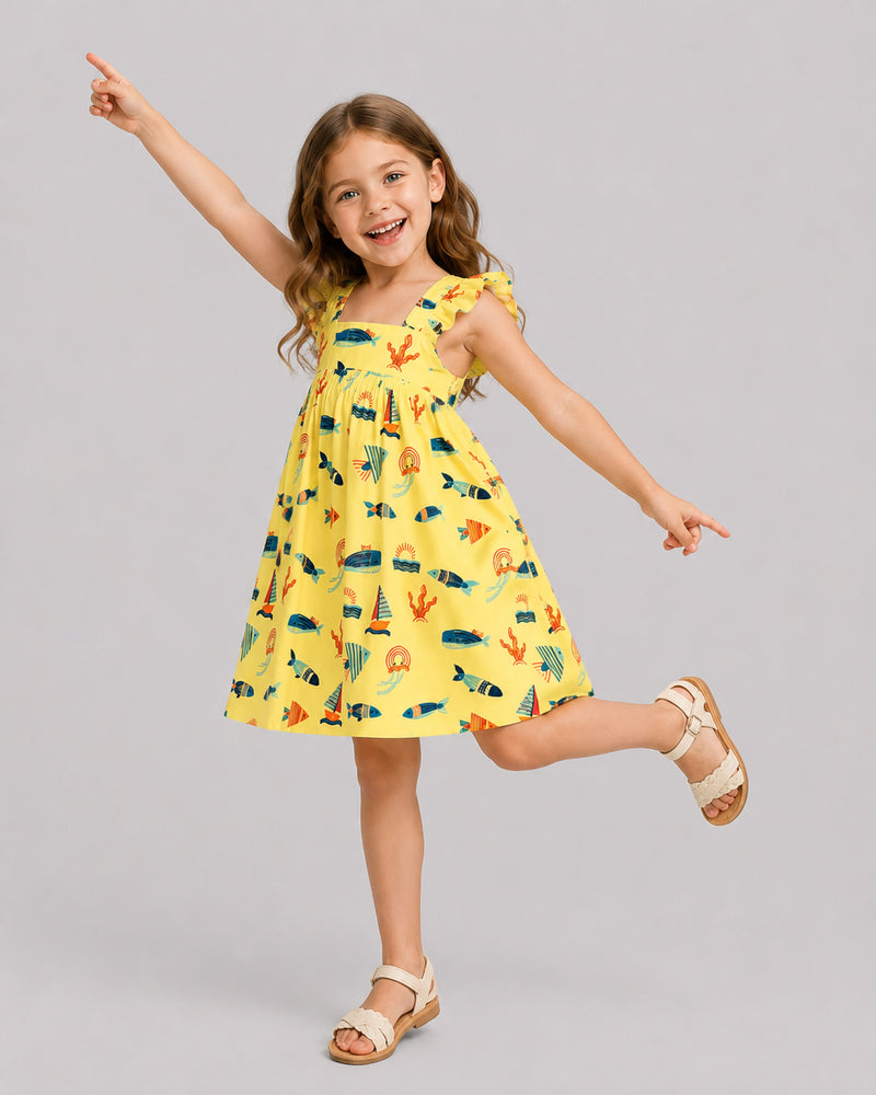 Girls ocean themed dress in yellow, sailboat and fish print, on model dancing pose