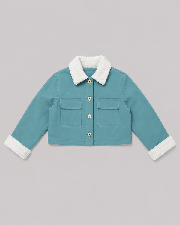 Flat lay of teal fleece jacket with sherpa collar and flap pockets, a cozy girls jacket
