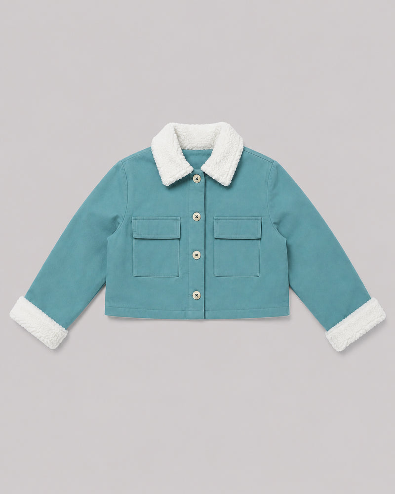 Flat lay of teal fleece jacket with sherpa collar and flap pockets, a cozy girls jacket