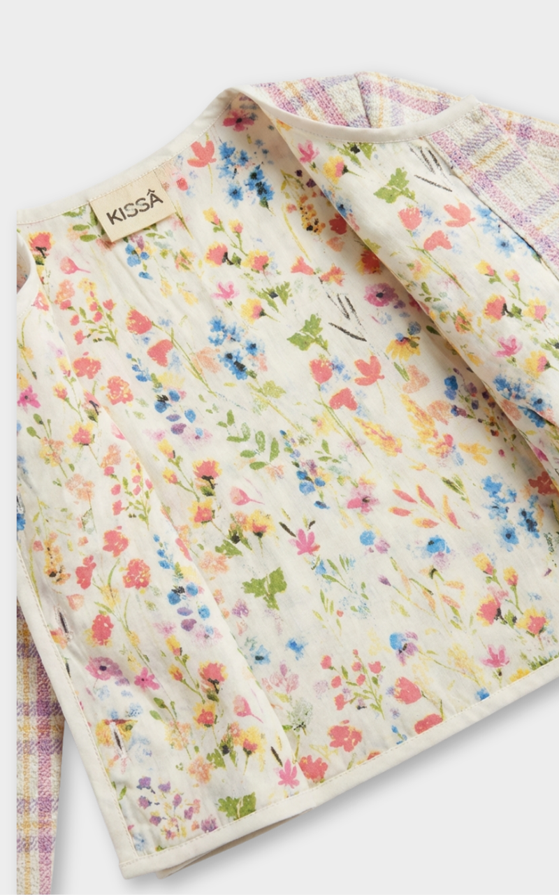 Closeup of wildflower print lining inside pink tweed plaid jacket, a pretty girls cardigan detail