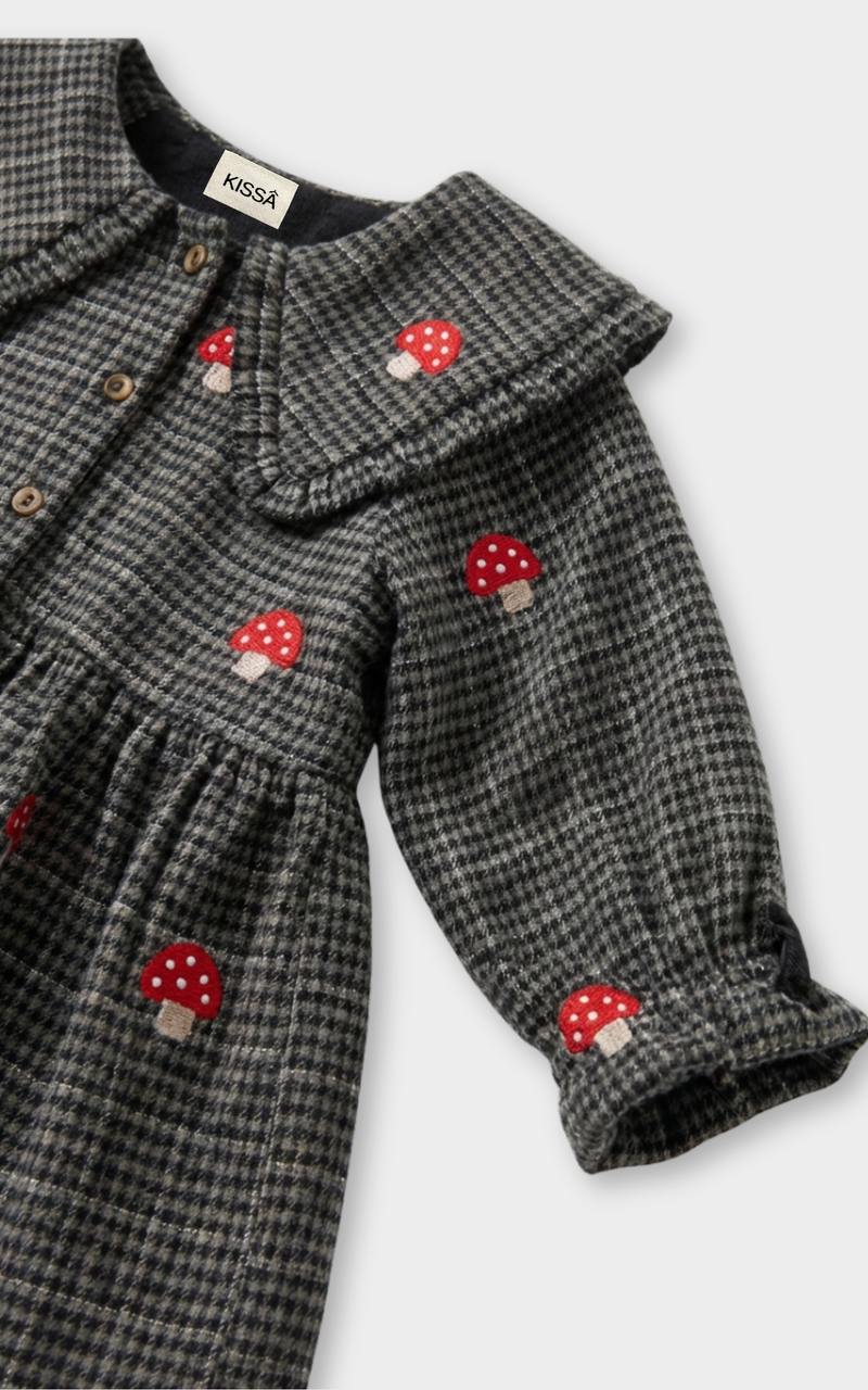 Closeup of red mushroom embroidery on grey houndstooth fabric, beautiful shirts for girl detail